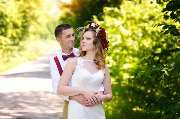 Šťastné krásné nevěsty a ženicha na pole na slunci — Stock fotografie