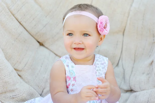 Niña feliz sentada en el sofá —  Fotos de Stock