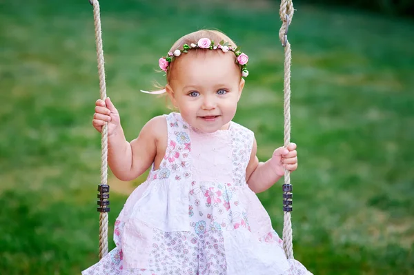 Entzückendes kleines Mädchen, das Spaß auf einer Schaukel hat — Stockfoto
