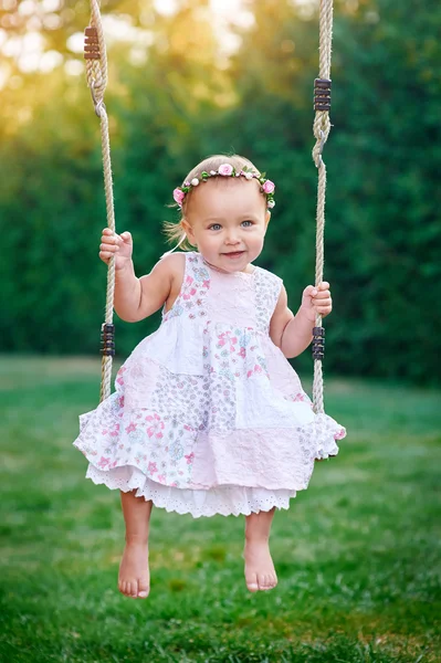 Entzückendes kleines Mädchen, das Spaß auf einer Schaukel hat — Stockfoto