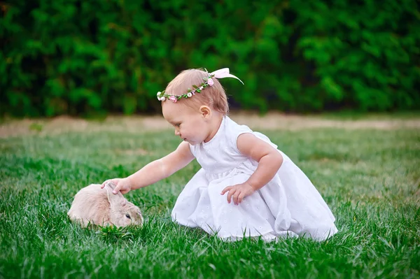 Cute dziewczynka z królik ma Wielkanoc w zielonej trawie — Zdjęcie stockowe
