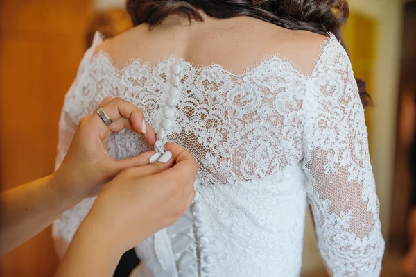 Bridesmaid is helping the bride to dress — Stock Photo, Image