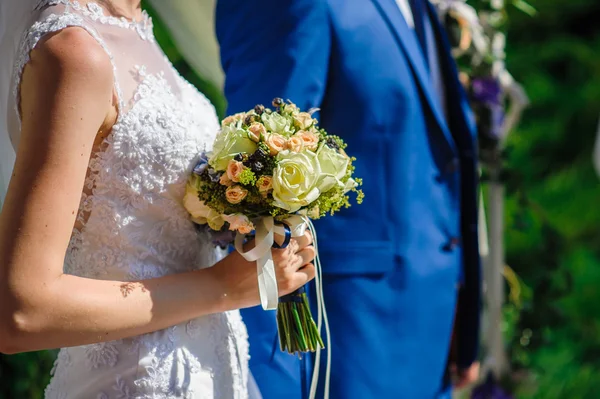 Noiva e noivo com um buquê de casamento para um passeio — Fotografia de Stock