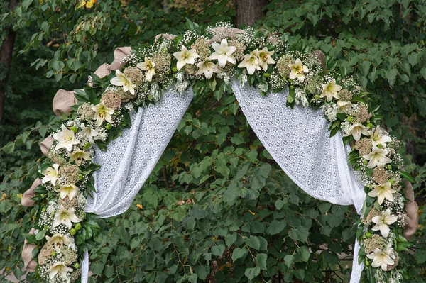 Arco de boda con flores dispuestas en el parque para una ceremonia de boda — Foto de Stock