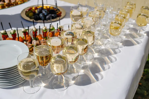 Foto de cerca con copas de champán en la mesa festiva — Foto de Stock
