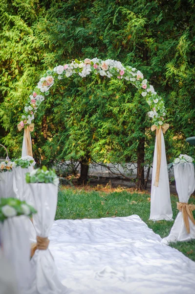 Arco de boda con flores dispuestas en el parque para una ceremonia de boda — Foto de Stock