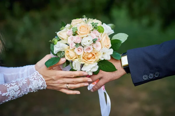 Novio le da a la novia un hermoso ramo de bodas — Foto de Stock