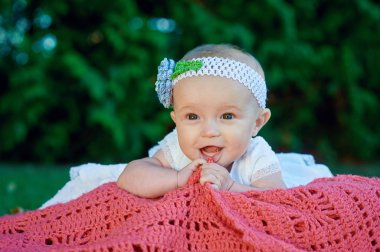 Mutlu küçük kız parkta bir battaniye yatan