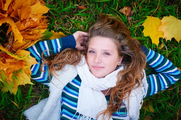 Woman lying on the grass in autumn park — Stock Photo, Image