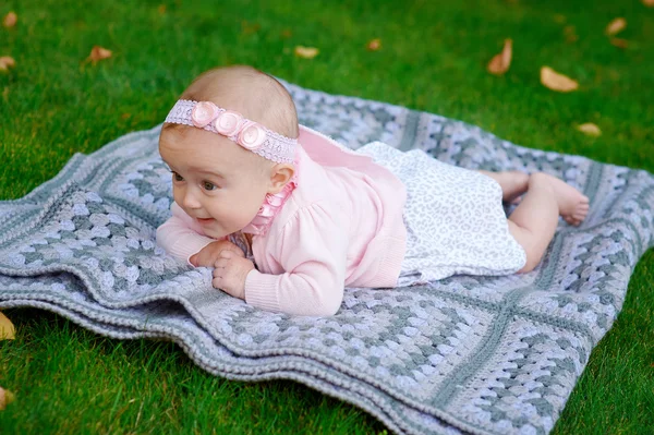 公園で毛布の上に横になっている幸せな少女 — ストック写真