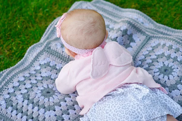 Gelukkig meisje liggend op een deken in het park — Stockfoto