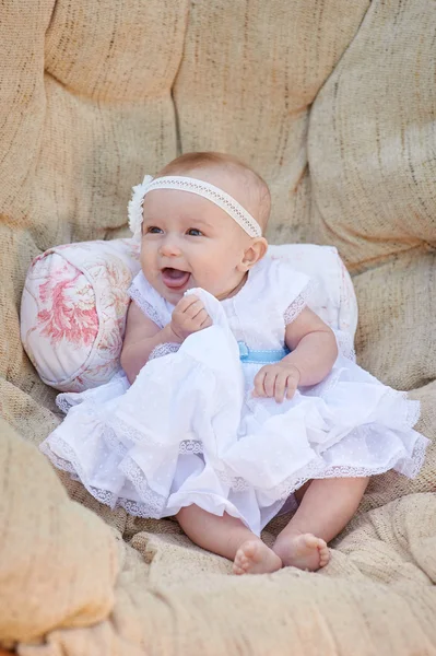 Niña feliz sentada en el sofá — Foto de Stock