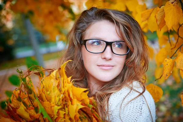 Beautiful woman with glasses walks in autumn park — Stock Photo, Image