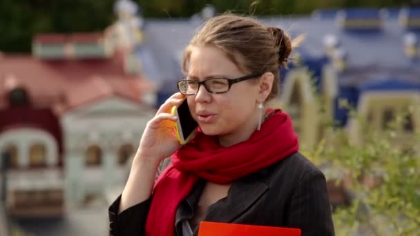 Hermosa mujer en gafas con carpeta roja en el teléfono — Vídeo de stock