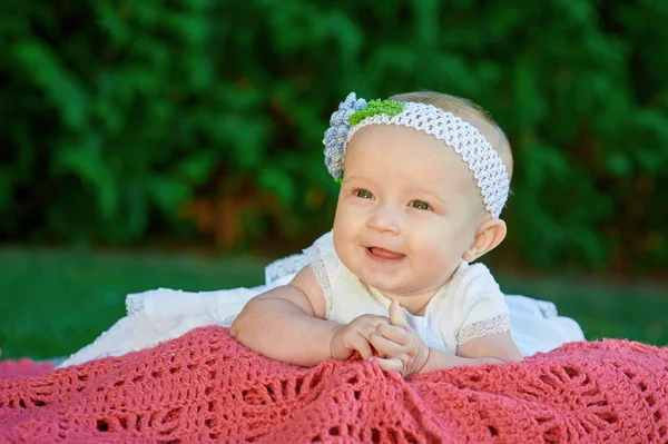 格子縞の毛布の美しい小さな女の赤ちゃんが横になっています。 — ストック写真