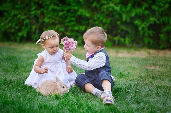 Liten pojke ger en flicka en bukett blommor — Stockfoto