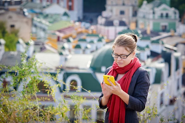 市でスマート フォンを用いたガラスの笑みを浮かべて女性実業家 — ストック写真