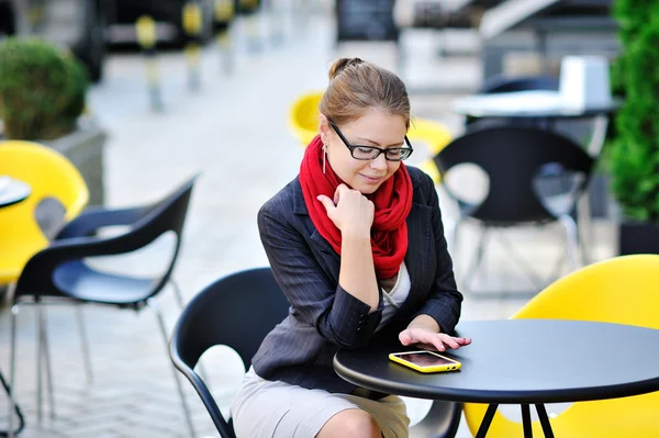 Mladé ženy používá chytrý telefon pro práci v kavárně — Stock fotografie