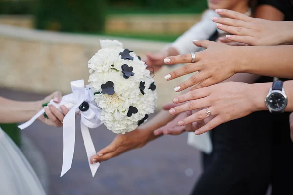 Bruden har en bröllop bukett och händer nått för det — Stockfoto