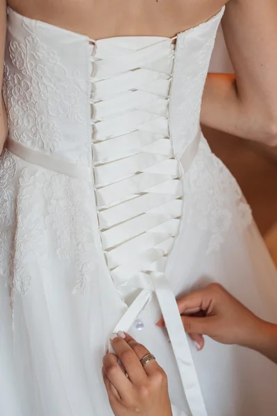 Bruidsmeisje is het helpen van de bruid te kleden — Stockfoto