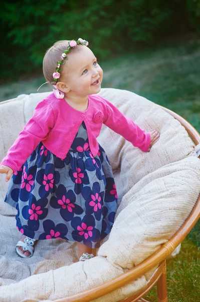 Glückliches kleines Mädchen, das auf der Couch sitzt und lächelt — Stockfoto