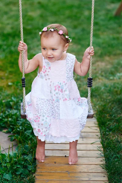 Entzückendes kleines Mädchen genießt eine Schaukelfahrt auf einem Spielplatz in einem Park — Stockfoto