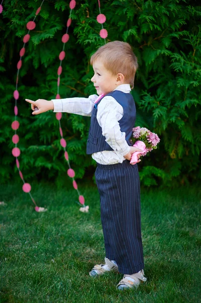 Petit garçon avec un bouquet de fleurs derrière son dos attendant la fille — Photo