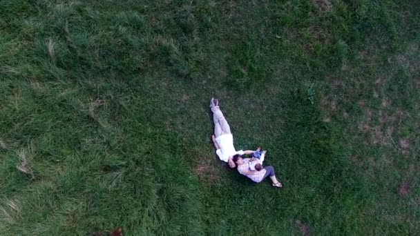 Familie liggen op het gras in de weide — Stockvideo