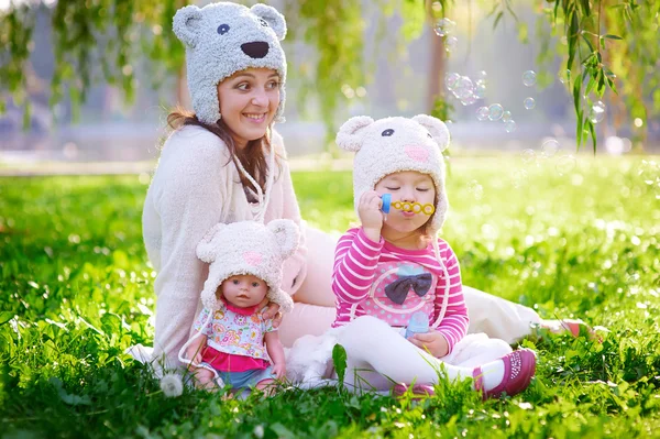Jovem mãe feliz e sua filha brincando no parque de verão — Fotografia de Stock