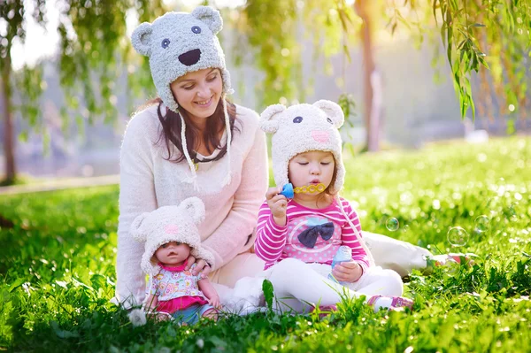 Szczęśliwa młoda matka i jej córka grając w lato park — Zdjęcie stockowe