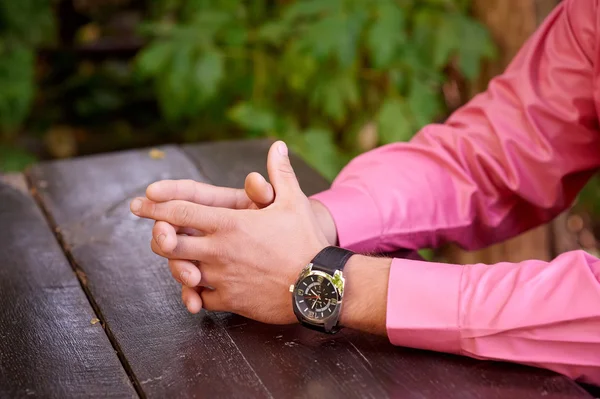 Close up of a man with his hands clasped in front of him — Stock Photo, Image