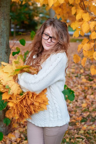 Young woman in sunglasses walking in autumn park — Stock Photo, Image