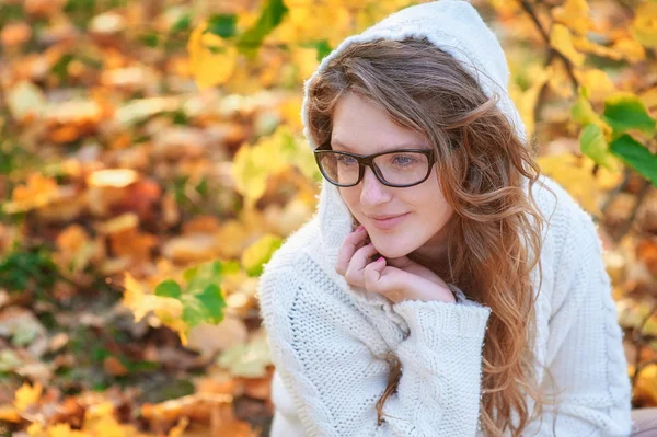 Young woman in sunglasses walking in autumn park — Stock Photo, Image