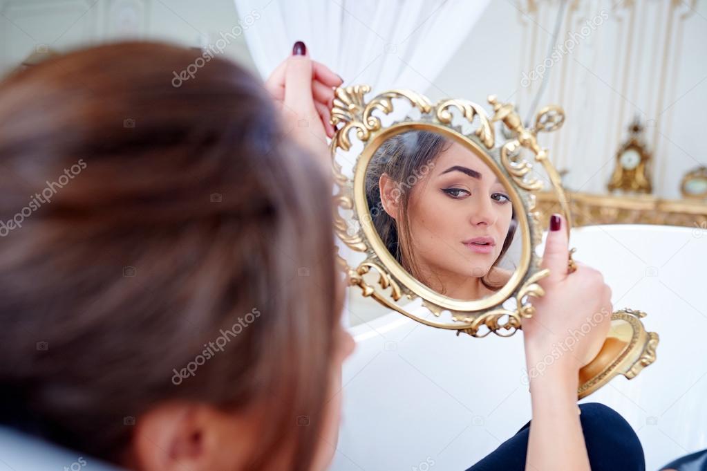 beautiful woman in the bathroom looking in the mirror