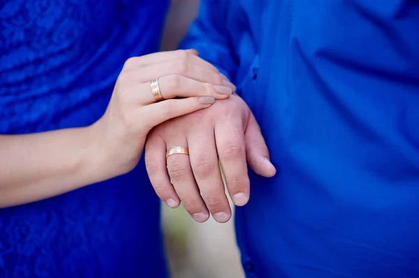 Mãos de duas pessoas amorosas em um fundo azul — Fotografia de Stock