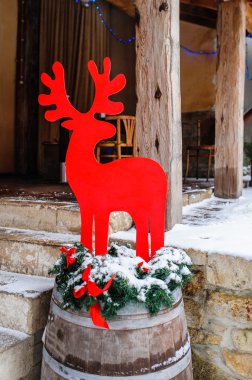 evin önünde kırmızı dekoratif geyik