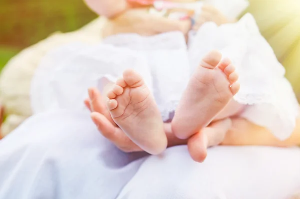 Neugeborene Babyfüße in den Händen der Mutter — Stockfoto