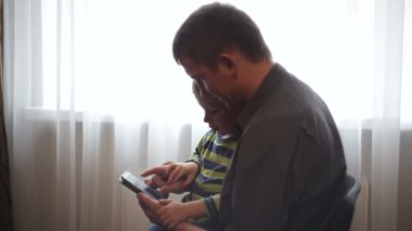 Baba ve oğlu izlerken resimleri ve videoları smartphone