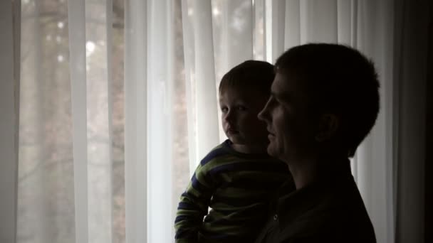 Silueta šťastný otec drží svého syna na jeho rukou — Stock video