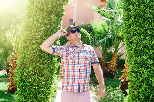 Homme dans un chapeau et des lunettes de soleil levant les yeux — Photo