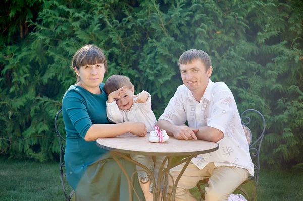 Familjen i parken vid bordet — Stockfoto