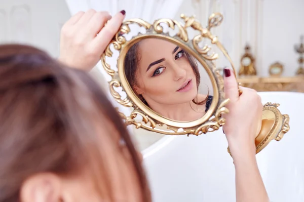 Mujer mirándose en el espejo — Foto de Stock