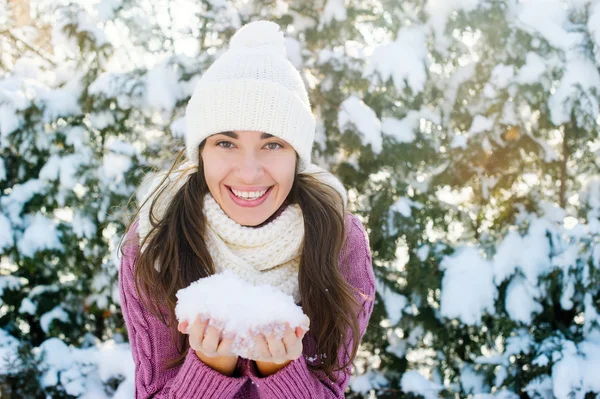 Mujer feliz sosteniendo nieve en el parque de invierno —  Fotos de Stock