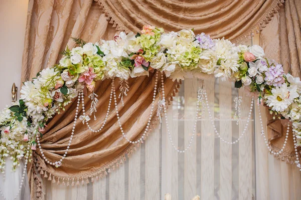 Beautiful white wedding arch decorated with pink and red flowers — Stock Photo, Image