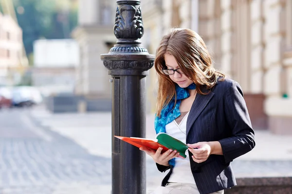 Estudante mulher bonita em óculos livro de leitura — Fotografia de Stock
