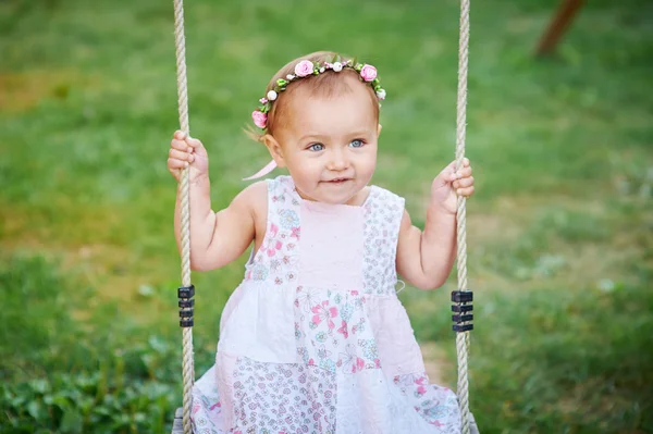 Liebenswertes Mädchen hat Spaß auf einer Schaukel an einem Sommertag — Stockfoto