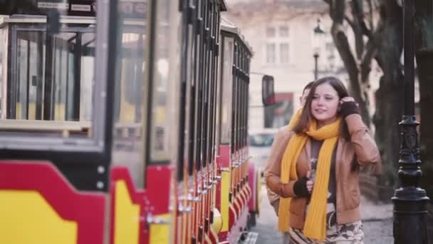 Jong koppel wandelen in het oude gedeelte van de stad in de buurt van tram — Stockvideo