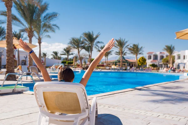 Mujer acostada en una tumbona junto a la piscina —  Fotos de Stock