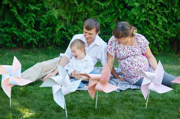 Mladá rodina hraje na piknik v parku léta — Stock fotografie