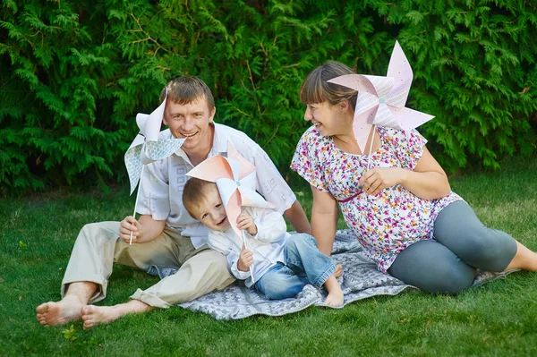 Ung familj spelar på en picknick i parken sommaren — Stockfoto